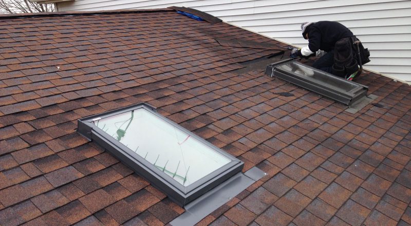 Man on roof replacing skylight